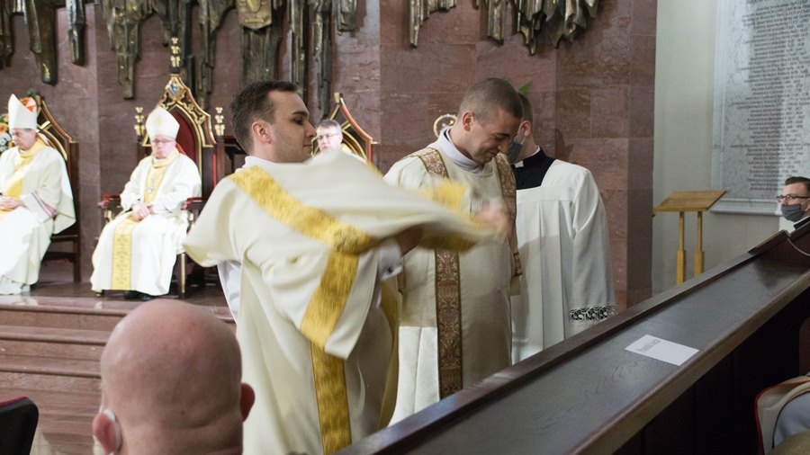 Diakoni zakładają dalmatyki - strój używany przez nich podczas liturgii