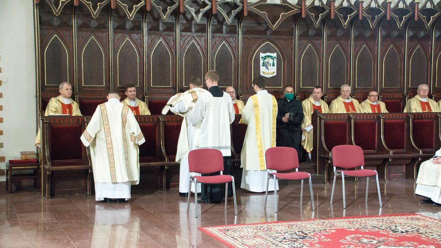 Diakoni zakładają dalmatyki - strój używany przez nich podczas liturgii